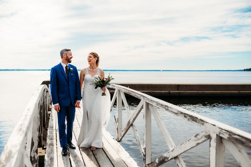 Bride and groom walking along dock at Britannia Yacht Club during wedding portraits