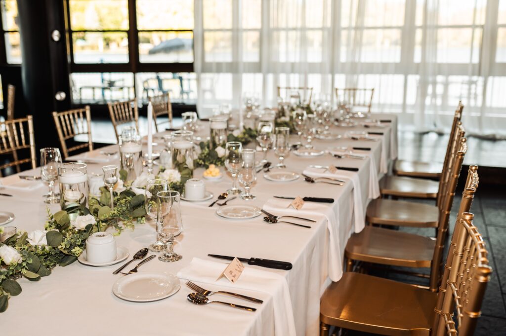 Reception tables inside Lago wedding venue with natural light overlooking Dow’s Lake in Ottawa
