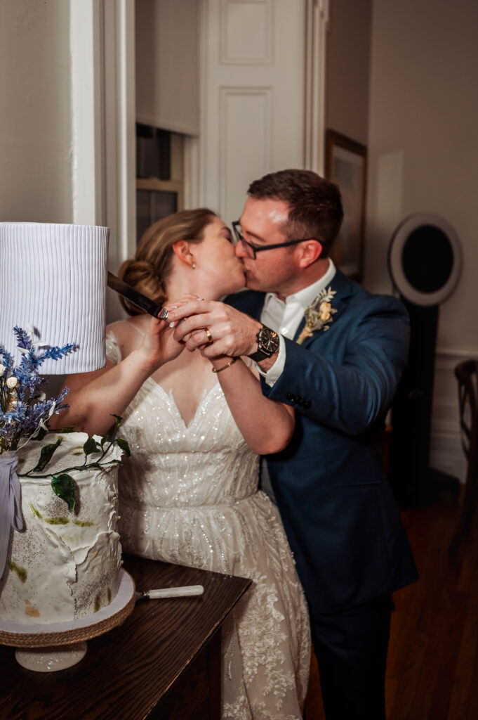 bride and groom cutting cake while posing