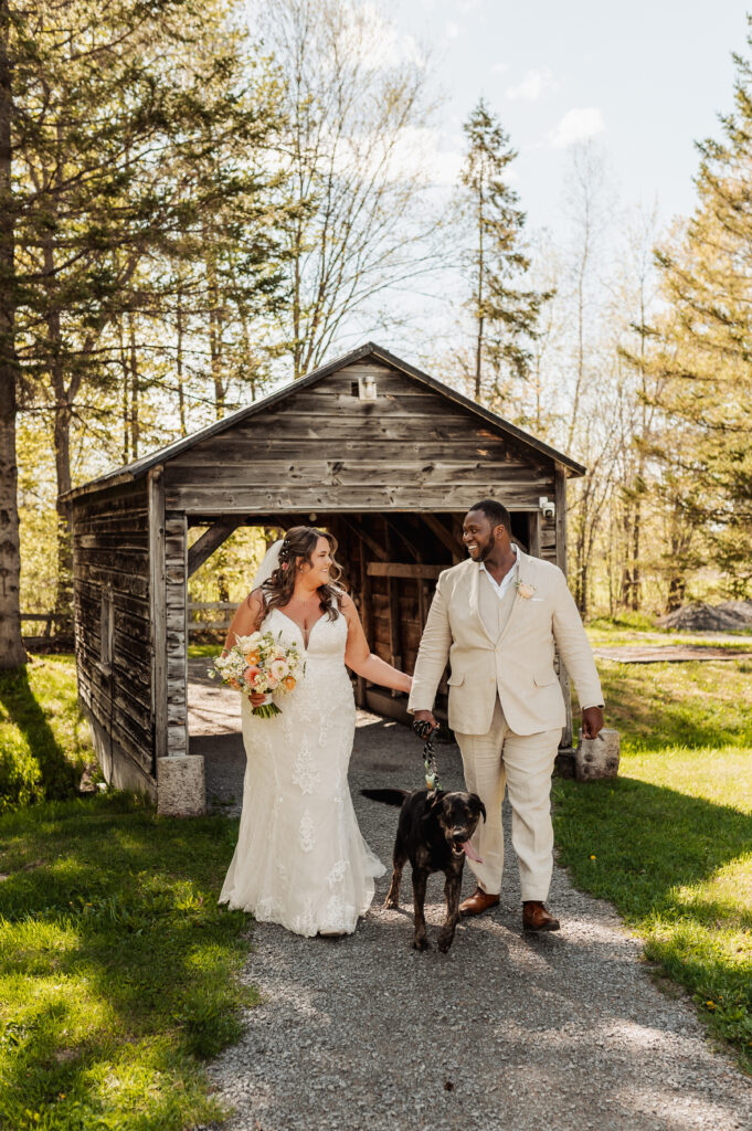 couple posing with their dog before the ceremony